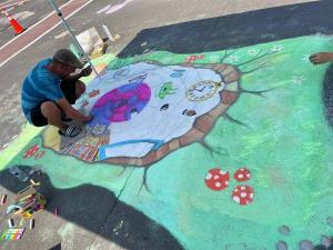 young man creating a chalk drawing during the chalk-a-lot event in waterloo, il