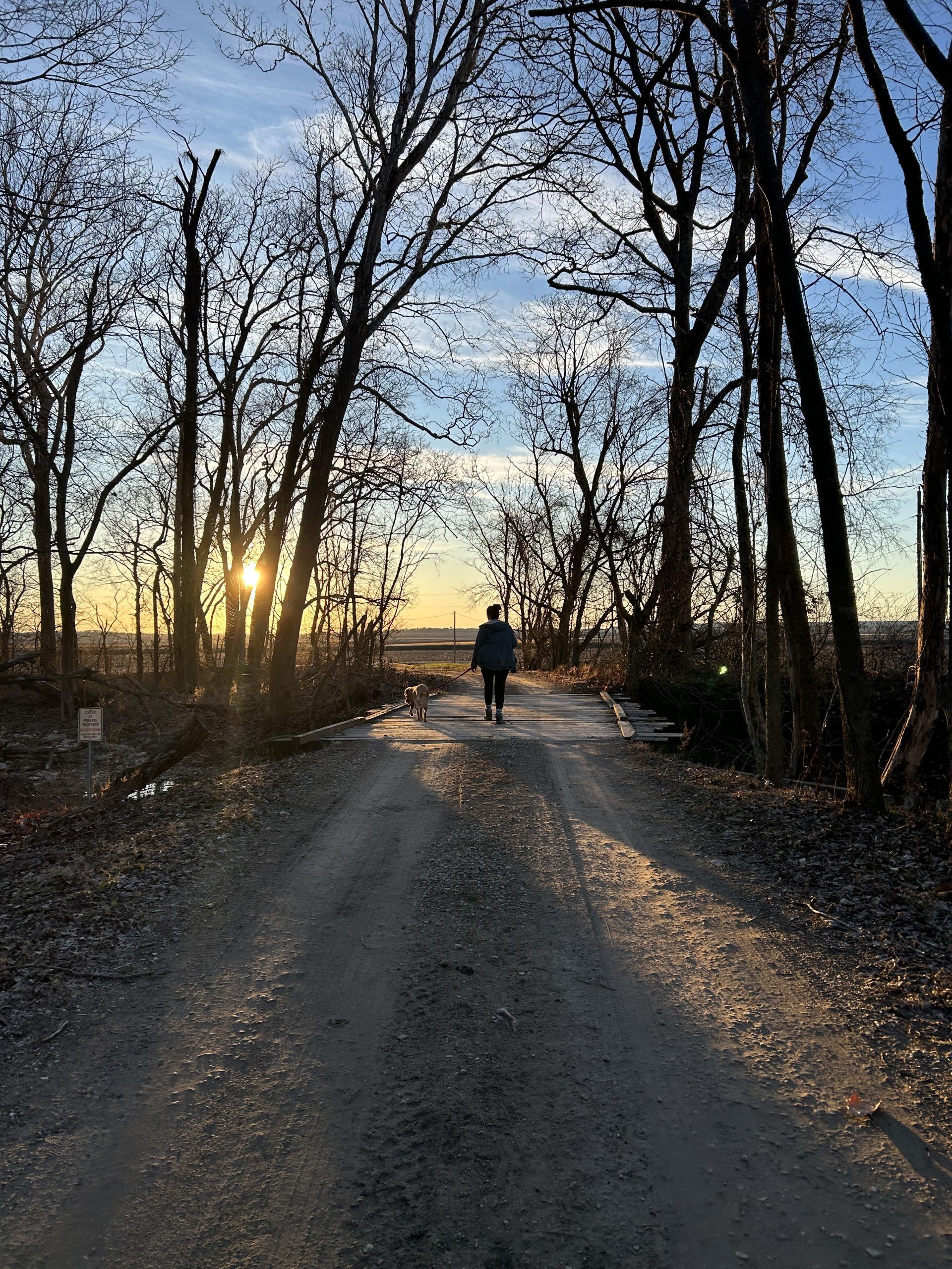 a woman hiking on a dirt road.