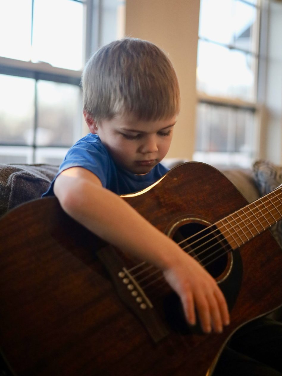 9.jpeg-Little-brother-playing-guitar-The-arts-14-25-first-place-A.-Williams